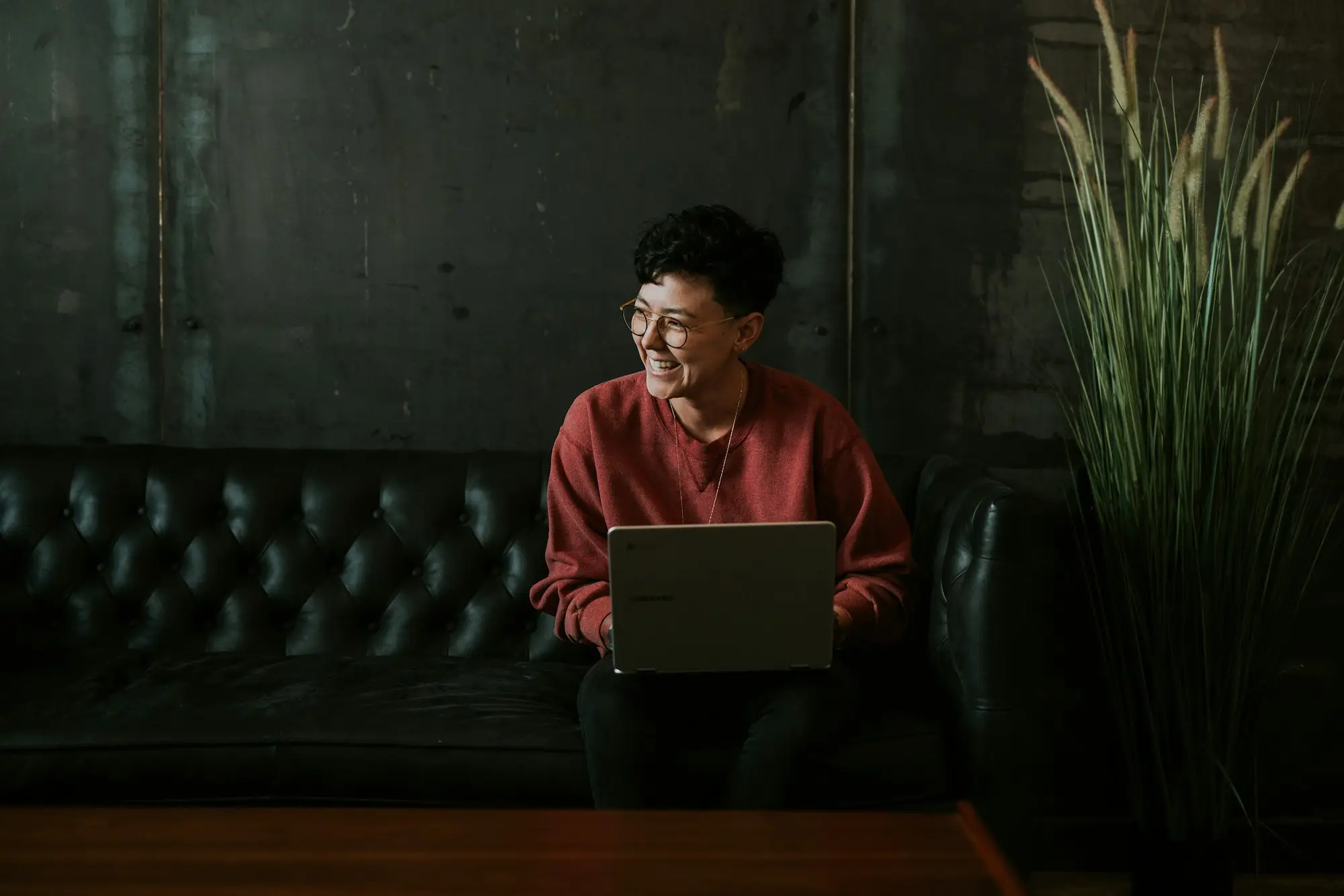 Business owner smiling while reviewing bank statements on a laptop