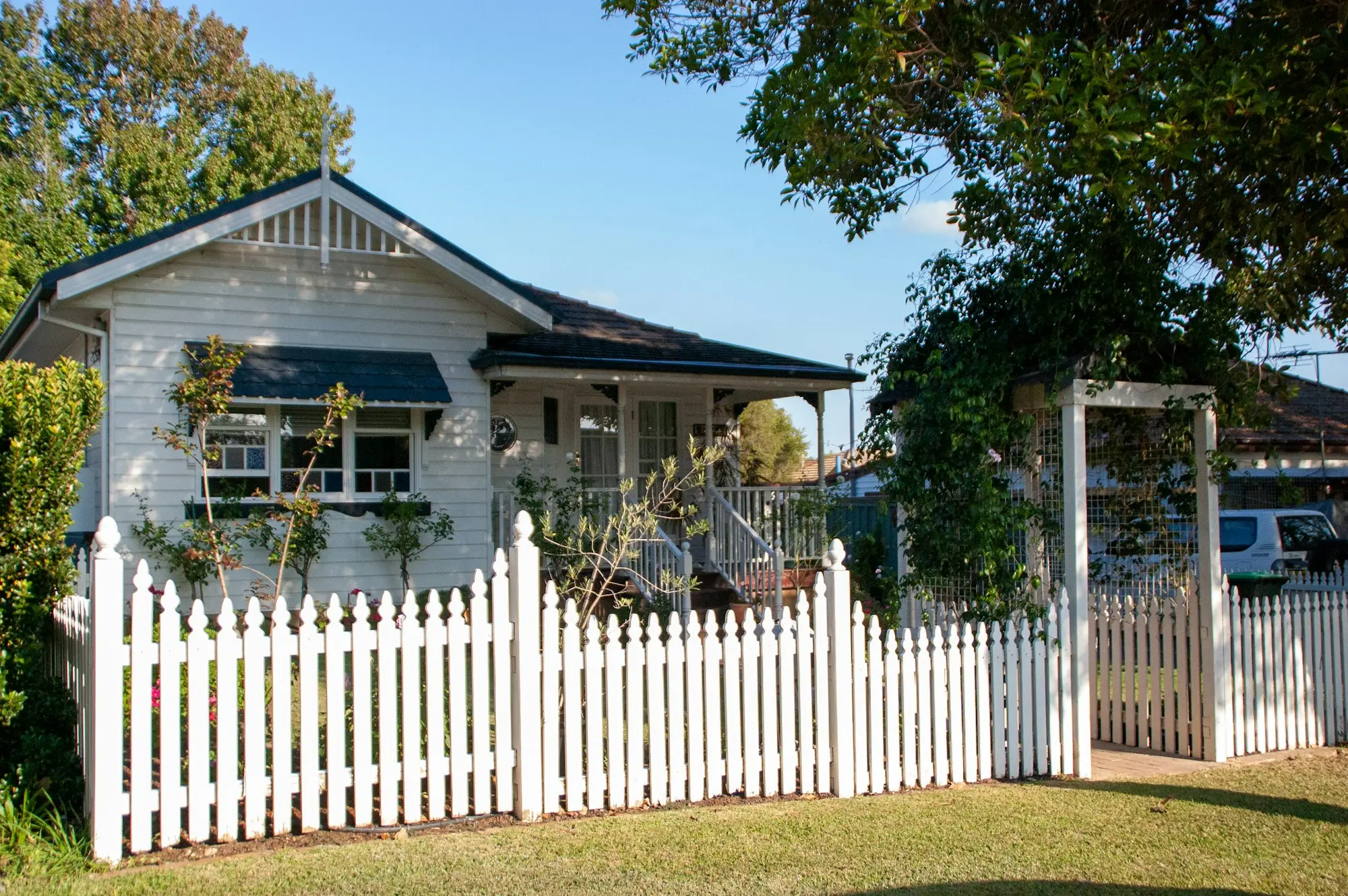 Weatherboard house with a white picket fence in suburban Sydney